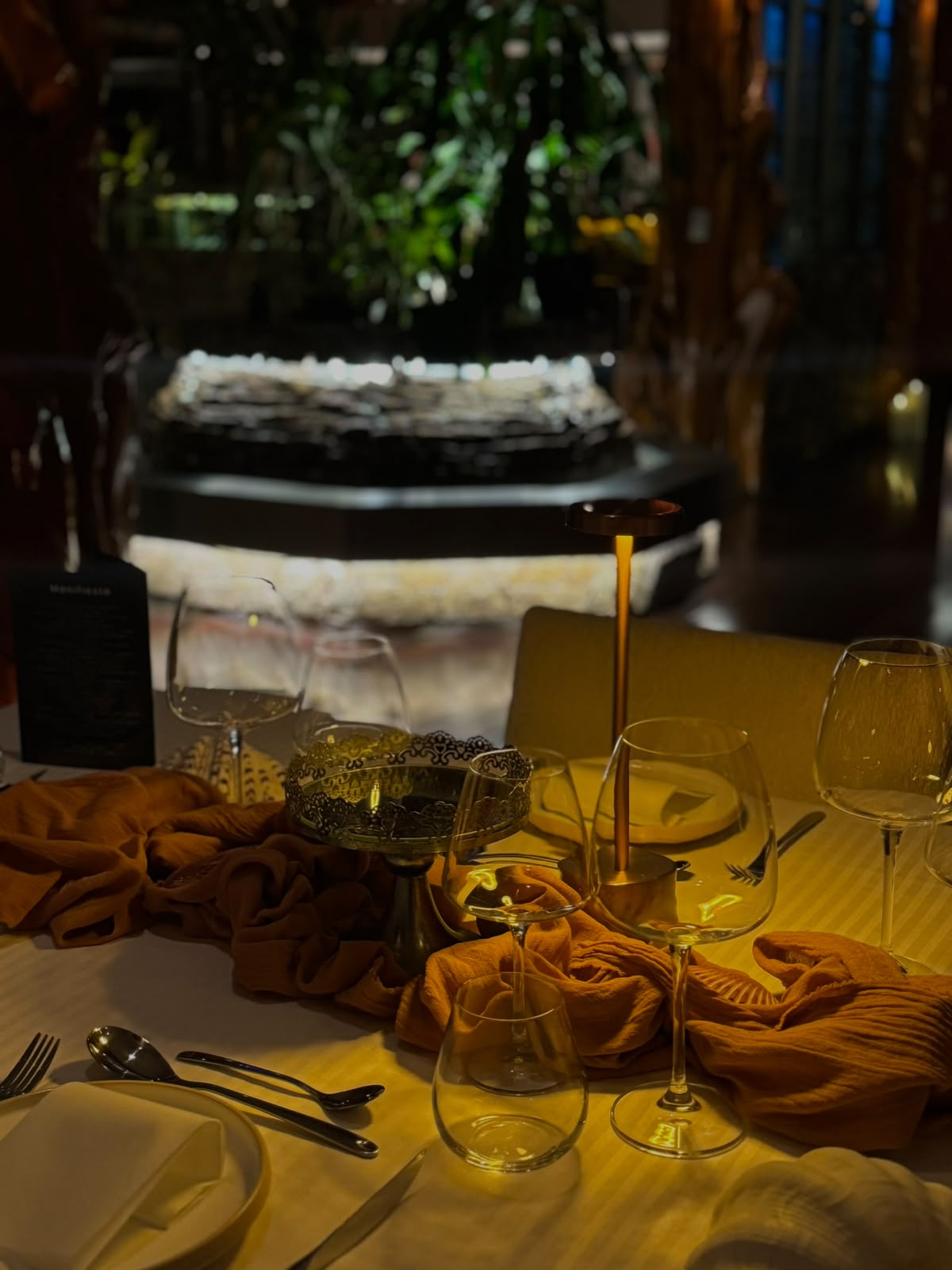 Detalle de mesa con lámparas doradas y telas color mostaza