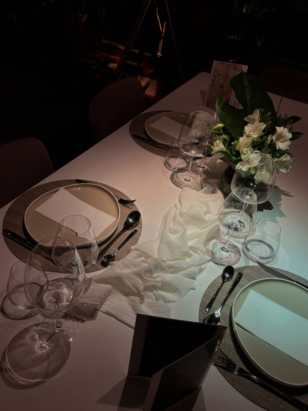 Mesa puesta con flores blancas y copas